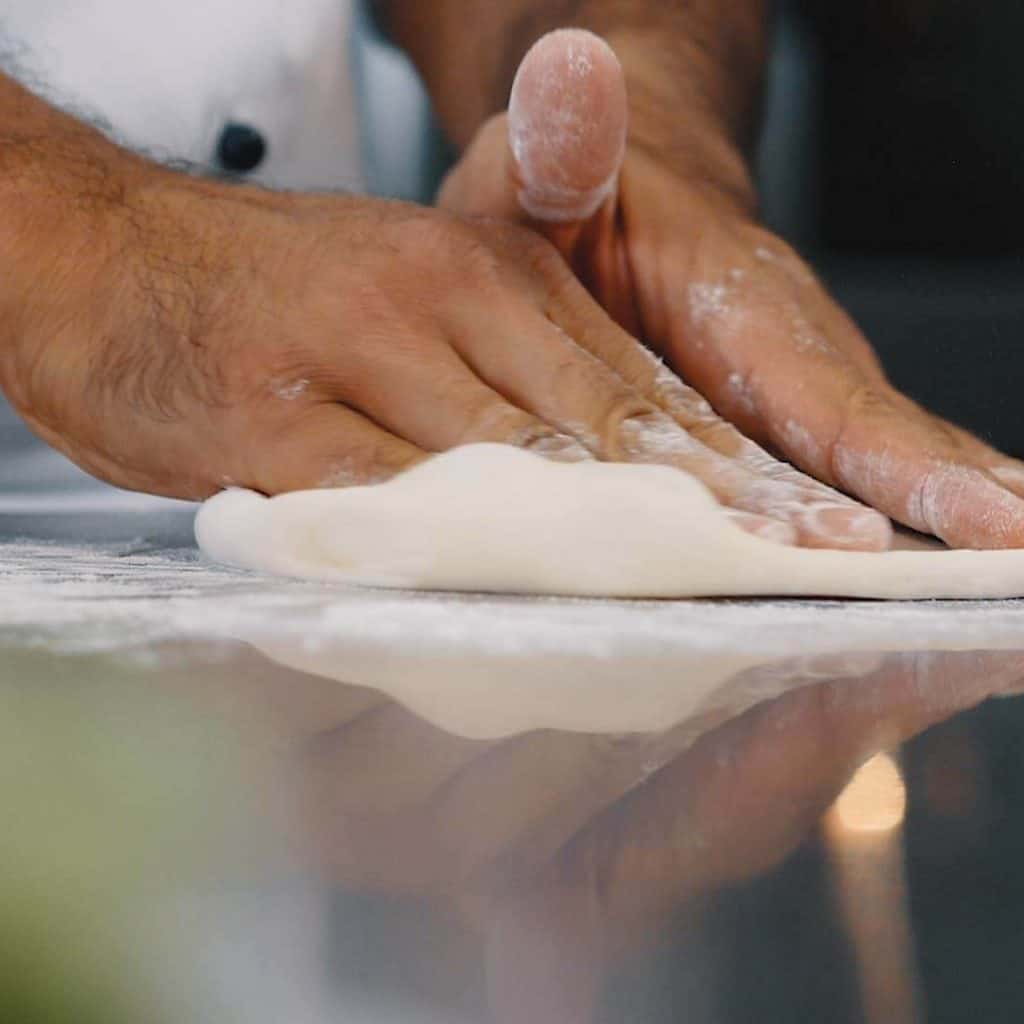 Zwei mehlige Hände kneten Pizzateig, Koch bei Vorbereitung für Pizzabacken, Rational AG, Foto Social Media Content, WINGMEN Media