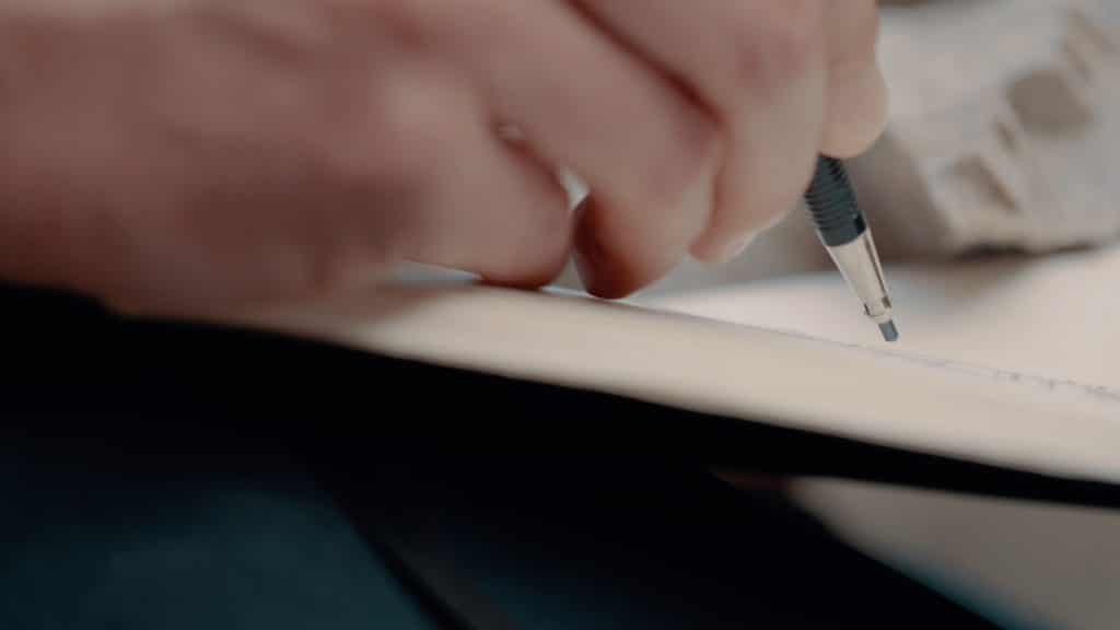Eine Hand mit Minenbleistift zeichnet in einem Notizbuch, innovativ, zukunftsfähige Immobilien, nordweis Unternehmensgruppe, Imagefilm, Moodfilm, WINGMEN Media