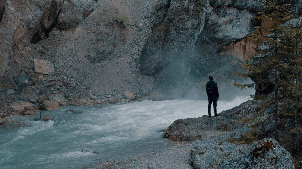Ein Mann steht an einem Fluss, Klamm, zwischen Felswand und Wald, Lebensräume, nordweis Unternehmensgruppe, Imagefilm, Moodfilm, WINGMEN Media