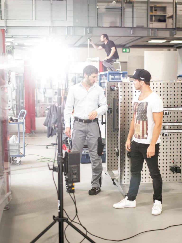 Regie und Darsteller bei Besprechung während Dreh, Aputure COB 300d, High-key, Verpackungsmaschinen, Somic GmbH, Behind The Scenes Fotografie, WINGMEN Media