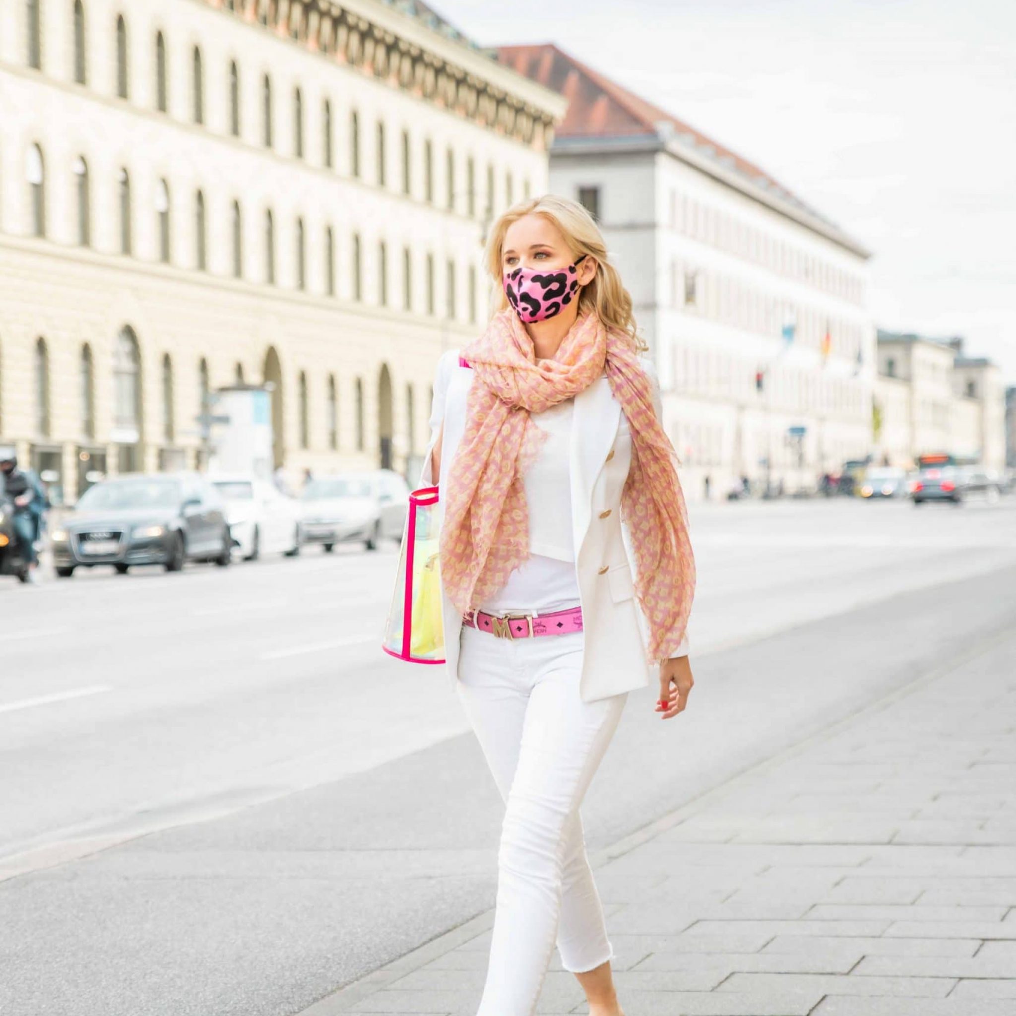 Eine Frau zu Fuß auf dem Weg durch die Stadt, sie trägt eine edle spitzen Maske, Smile for Change Maske, My Blossom, Produktfotografie, Lifestylefotografie, WINGMEN Media
