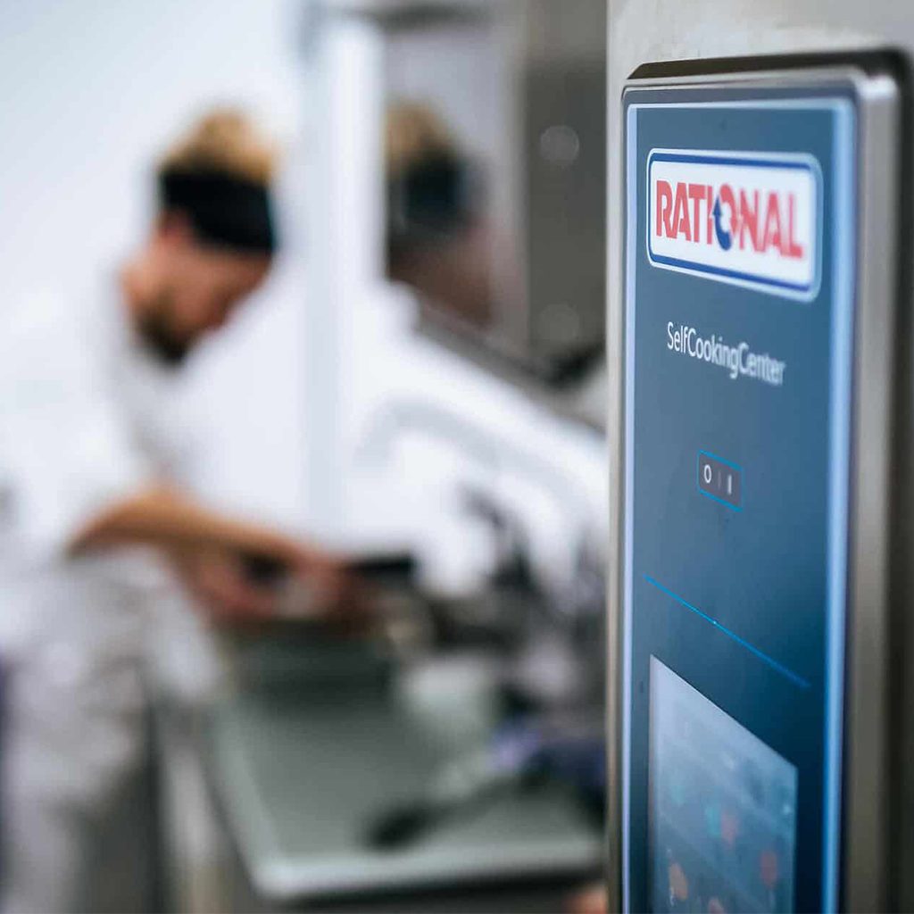 PRODUKTFILM 51 Nahaufnahme eines Rational SelfCookingCenter Dämpfers, Koch im Hintergrund bei Zubereitung, Rational AG, Unternehmensfotos, Social Media Content, WINGMEN Media