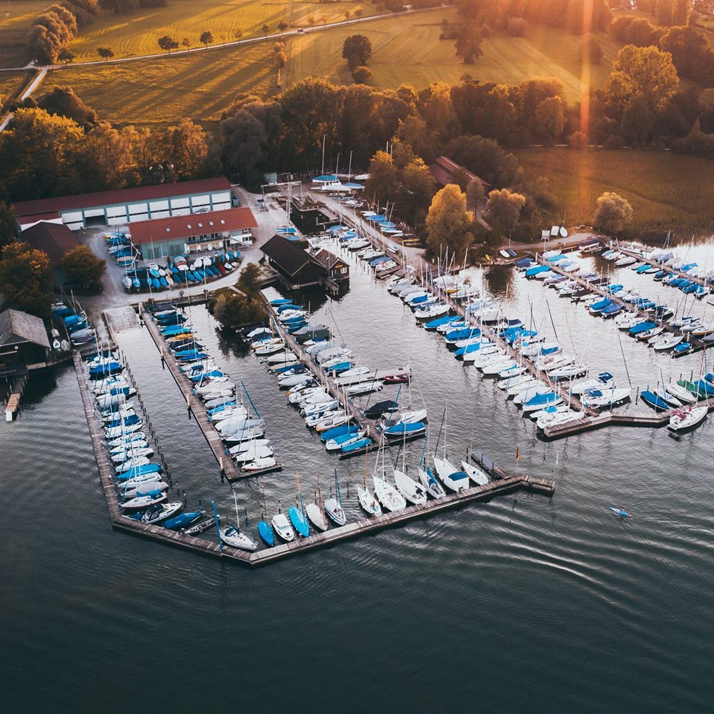TOURISMUSFILM 50 Drohnenaufnahme vom Sportboothafen Stippelwirft in Prien am Chiemsee bei Sonnenaufgang, Prien Tourismus GmbH, Tourismuskampagne, Social Media, WINGMEN Media