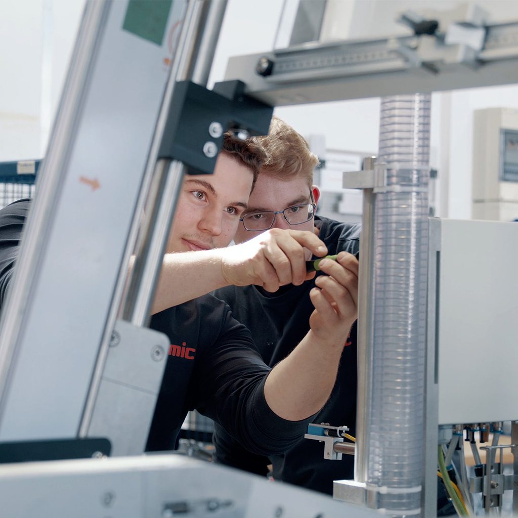 Zwei junge Männer bei der Arbeit an einer Maschine, Ausbildung zum Elektriker für Betriebstechnik, Verpackungsmaschinen, SOMIC, Recruitingfilm, WINGMEN Media