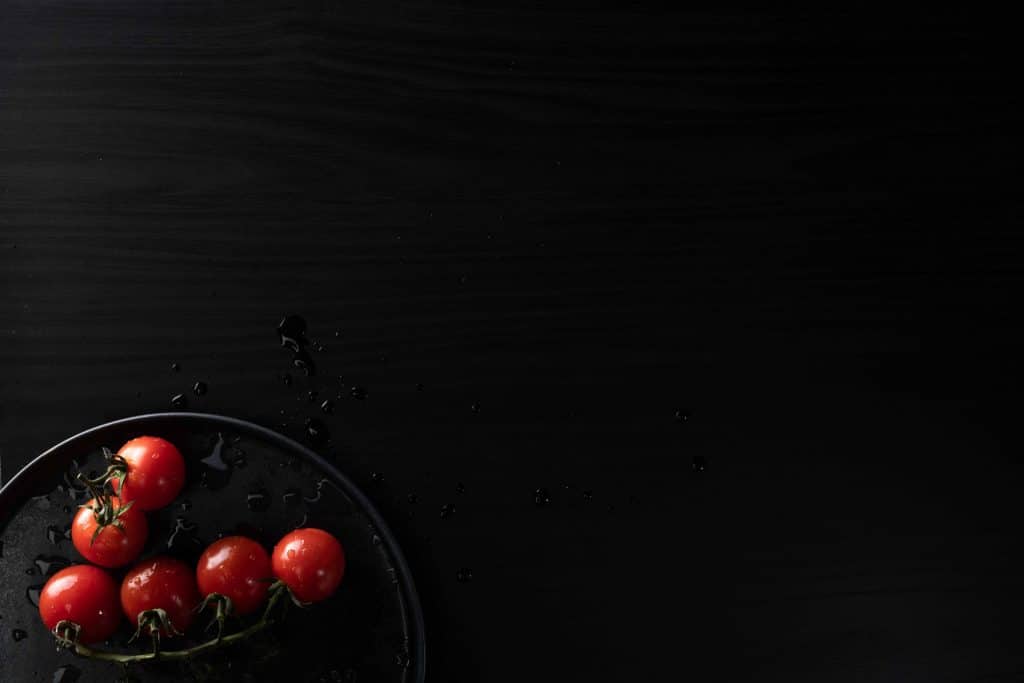 Teller mit Tomaten auf feuchtebeständigem dunklen Dekor mit Holzoptik, Holzdekor, Schattdecor, Produktfotografie, WINGMEN Media