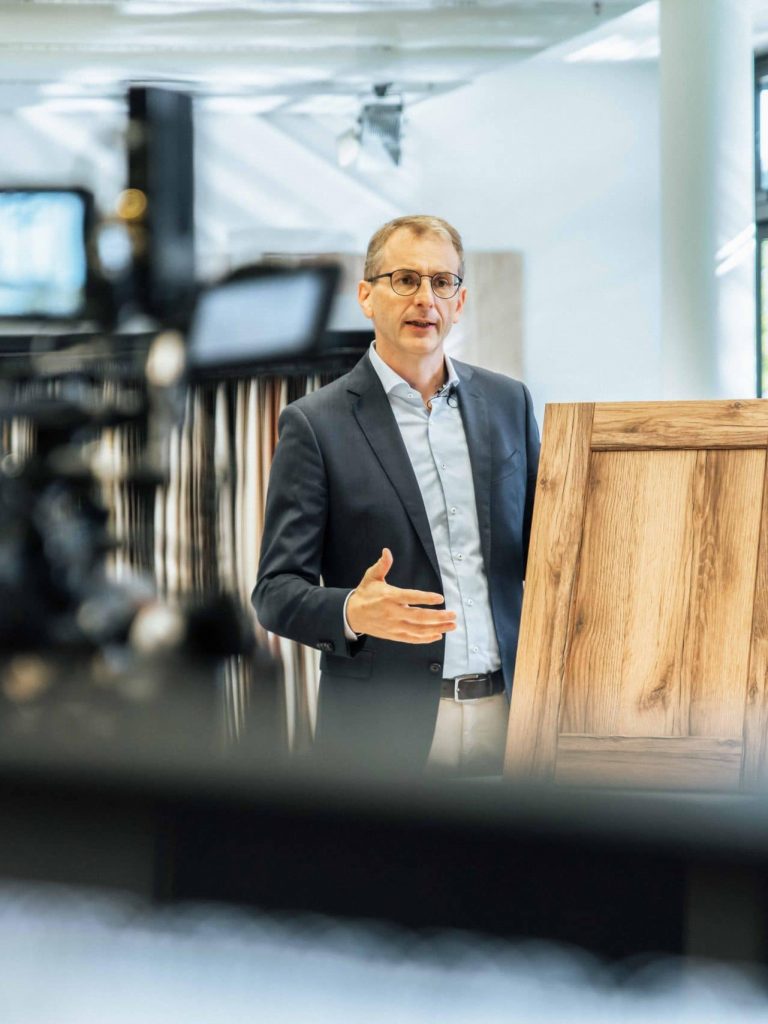 Filmdreh von einer Person bei der Präsentation der Funktionen und Designs des Holzdekors, helles Dekor mit Holzoptik, Schattdecor, Behind The Scenes Fotografie, WINGMEN Media