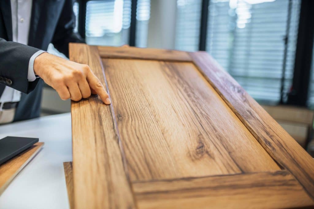 Hand die auf Detail Übergang von hellem Dekor mit Holzoptik zeigt, Schattdecor, Unternehmensfotografie, Produktfotografie, WINGMEN Media