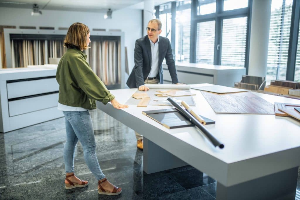 zwei Personen bei Entwicklung von Holzdekoren an einem großen Tisch, Schattdecor, Unternehmensfotografie, Behind The Scenes Fotografie, WINGMEN Media